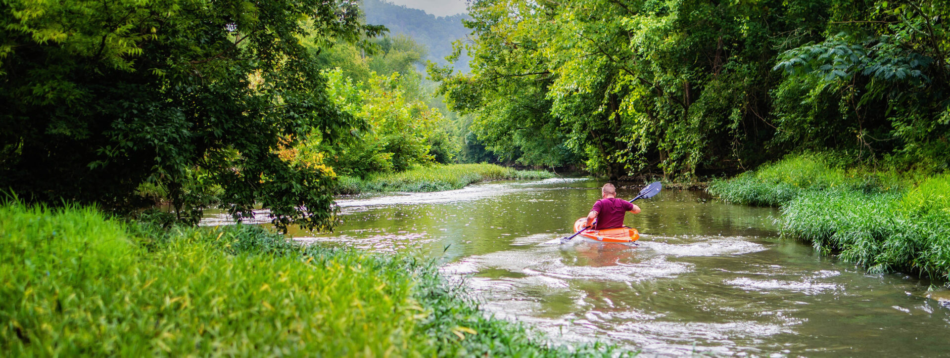 person kayaking down the river